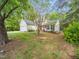 Side view of a charming two-story home with red shutters and a well-maintained lawn with mature trees at 5504 Cumberland Plain Dr, Raleigh, NC 27616