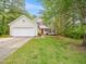 Charming two-story home with a two-car garage, red shutters, a well-maintained lawn, and mature trees at 5504 Cumberland Plain Dr, Raleigh, NC 27616