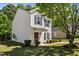 Inviting home featuring neat landscaping and a welcoming front porch, surrounded by mature trees and green foliage at 5801 Forest Point Rd, Raleigh, NC 27610