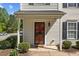 Close-up of home's entrance with a decorative security door, manicured shrubs, and a cozy, welcoming ambiance at 5801 Forest Point Rd, Raleigh, NC 27610