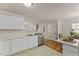 Bright kitchen featuring stainless steel appliances, white cabinets, and an adjacent breakfast area at 5801 Forest Point Rd, Raleigh, NC 27610