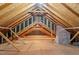 Unfinished attic space with exposed wood beams and a brick chimney at 605 Glen Eden Dr, Raleigh, NC 27612