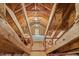 Unfinished attic space with exposed wood beams, limited natural light, and plywood flooring at 605 Glen Eden Dr, Raleigh, NC 27612