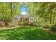 Lush backyard with mature trees, manicured lawn, and a serene ambiance perfect for relaxation at 605 Glen Eden Dr, Raleigh, NC 27612