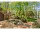 Lush backyard with a stone terrace, a small pond, and mature trees, perfect for outdoor relaxation at 605 Glen Eden Dr, Raleigh, NC 27612
