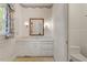 Elegant bathroom featuring a white vanity with drawers, an framed mirror, sconces, and blue and white wallpaper at 605 Glen Eden Dr, Raleigh, NC 27612