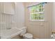 Small bathroom featuring wall-mounted sink, toilet, and striped wall paper at 605 Glen Eden Dr, Raleigh, NC 27612