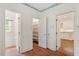 Hallway leading to various rooms, featuring pantry shelving and brick flooring at 605 Glen Eden Dr, Raleigh, NC 27612