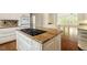 Bright kitchen featuring granite countertops, white cabinetry, and a gas cooktop island at 605 Glen Eden Dr, Raleigh, NC 27612
