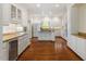 Bright kitchen with granite countertops, white cabinetry, stainless appliances, and hardwood floors at 605 Glen Eden Dr, Raleigh, NC 27612