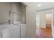 Laundry room with washer, dryer, built-in cabinets and brick flooring at 605 Glen Eden Dr, Raleigh, NC 27612