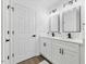 Modern bathroom featuring double sinks, white cabinetry, dark hardware and hardwood floors at 606 Cecil Street St, Durham, NC 27707