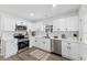 Bright kitchen with all-white cabinetry, stainless appliances, and modern countertops at 606 Cecil Street St, Durham, NC 27707