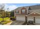 View of a two story townhome with a two car garage, landscaping and sunny sky at 617 Sealine Dr, Cary, NC 27519