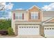 Charming townhome featuring a stone facade and two-car garage under a bright blue sky at 617 Sealine Dr, Cary, NC 27519
