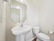 A well-lit powder room with a pedestal sink, modern faucet, and a round mirror at 617 Sealine Dr, Cary, NC 27519
