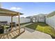 Backyard featuring a pergola covered patio with grill, fenced yard with grass, and a basketball hoop on garage at 6511 Academic Ave, Raleigh, NC 27616