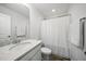 Bright bathroom featuring a modern vanity with stone countertop and a shower with a white curtain at 6511 Academic Ave, Raleigh, NC 27616