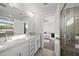 Bathroom with double sink vanity and open door, and glass-enclosed shower at 6511 Academic Ave, Raleigh, NC 27616