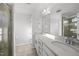 Bathroom featuring double sinks, a vanity with a stone countertop, and a glass-enclosed shower at 6511 Academic Ave, Raleigh, NC 27616