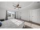Bright bedroom featuring a tray ceiling, ceiling fan, and a large window with neighborhood views at 6511 Academic Ave, Raleigh, NC 27616
