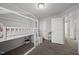 Bright bedroom featuring a stylish lofted twin bed with a semi-sheer canopy, neutral color palette and view of hall at 6511 Academic Ave, Raleigh, NC 27616