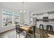 Sunlit dining area adjacent to the kitchen with wooden table, stylish chairs, and cheerful natural light at 6511 Academic Ave, Raleigh, NC 27616