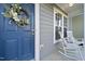 Close-up of a charming front porch with rocking chairs and a wreath on the door at 6511 Academic Ave, Raleigh, NC 27616