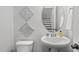 Stylish powder room with a pedestal sink, decorative wall art, and modern fixtures, providing a touch of elegance at 6511 Academic Ave, Raleigh, NC 27616