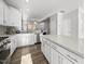 Open kitchen boasts white cabinetry, stainless appliances, and an island with quartz countertops at 6511 Academic Ave, Raleigh, NC 27616