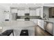 A well-appointed kitchen features an island with seating, white cabinets, stainless steel appliances, and stylish backsplash at 6511 Academic Ave, Raleigh, NC 27616