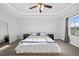 Bright main bedroom featuring neutral walls, carpet, and a ceiling fan with attractive tray ceiling detail at 6511 Academic Ave, Raleigh, NC 27616