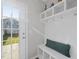 Convenient mudroom area with bench seating, shelving, and hooks, perfect for entryway organization, with a back door at 6511 Academic Ave, Raleigh, NC 27616