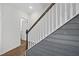 A stylish staircase features wood handrail, white spindles, and gray wainscoting, blending modern design with classic charm at 6511 Academic Ave, Raleigh, NC 27616