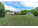 Expansive backyard featuring multiple homes, lush green grass, mature trees, and a serene, park-like setting at 6512 Southern Times Dr, Raleigh, NC 27603