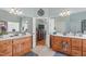 Dual vanities in bathroom with separate mirrors and sinks. A doorway leads to the primary bedroom at 6512 Southern Times Dr, Raleigh, NC 27603