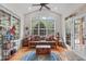 Bright sunroom featuring vaulted ceilings, a ceiling fan, large windows, hardwood floors and stylish furniture at 6512 Southern Times Dr, Raleigh, NC 27603