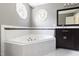 Bathroom featuring soaking tub, double vanity, and octagon windows at 7 Wythebrook Ln, Durham, NC 27713