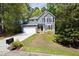 Charming gray home with white trim, lush landscaping, and a two-car garage on a sunny day at 7 Wythebrook Ln, Durham, NC 27713