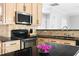 Bright kitchen features stainless steel appliances, black countertops, and light wood cabinets at 7 Wythebrook Ln, Durham, NC 27713