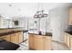 Sunlit kitchen boasts an island with black countertop, light wood cabinets, and adjacent breakfast area at 7 Wythebrook Ln, Durham, NC 27713