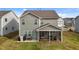 Back exterior featuring a screened porch, grill, and a well-maintained yard at 7205 Tillage Rd, Mebane, NC 27302