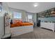 Cozy bedroom with built in storage and shelving, featuring a soft green wall and light-filled windows at 7205 Tillage Rd, Mebane, NC 27302