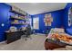 Bedroom with blue painted walls, a wooden desk, neutral carpet, a wooden bed, and shelves full of figurines at 7205 Tillage Rd, Mebane, NC 27302