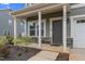 Inviting front porch with stone accents and a contemporary gray front door at 7205 Tillage Rd, Mebane, NC 27302