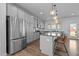 Open kitchen featuring stainless steel appliances, gray cabinets, and a large center island at 7205 Tillage Rd, Mebane, NC 27302