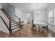 Bright living room featuring hardwood floors, a staircase, and dining area with natural light at 7205 Tillage Rd, Mebane, NC 27302