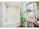 Bright bathroom featuring a tub-shower combo and a shelving unit with decorative plants at 7228 Lowery Meadow Dr, Wendell, NC 27591