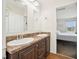 A bathroom with a double sink vanity, mirrors, and a glimpse into a bedroom at 7228 Lowery Meadow Dr, Wendell, NC 27591