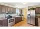 Kitchen with stainless steel appliances, wood cabinets and adjacent laundry area offers convenience and style at 7228 Lowery Meadow Dr, Wendell, NC 27591